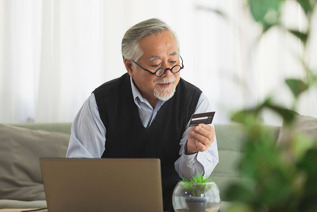 asian elderly man use cradit card shopping online