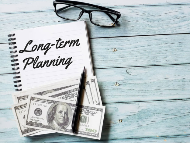 business and finance concept phrase long term planning written on note book with fake money