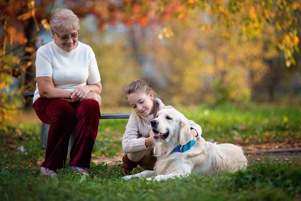 happy grandmother with granddaughter and their favourite cute dog