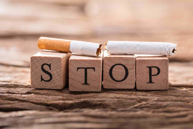 cigarette and wooden blocks showing stop word