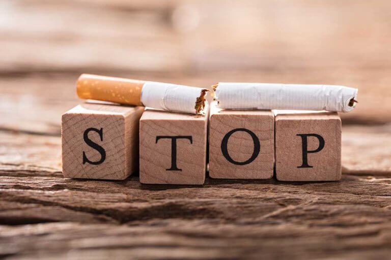 cigarette and wooden blocks showing stop word
