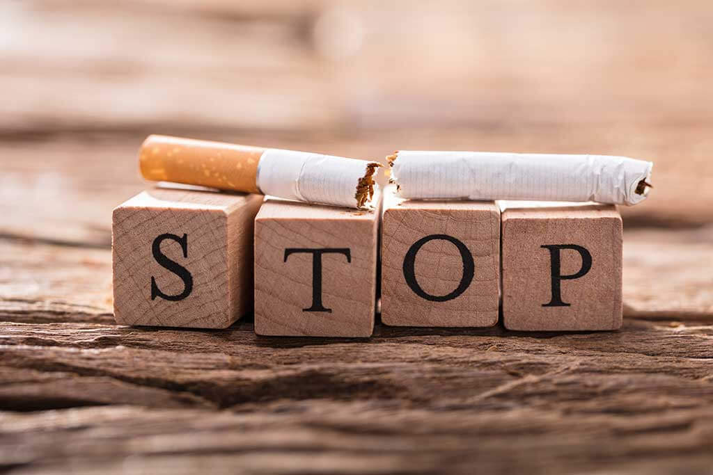 cigarette and wooden blocks showing stop word