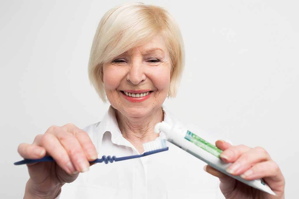 close up and cut vuew of a woman putting some toothpaste