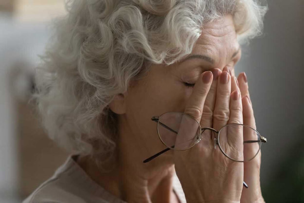close up of tired elderly woman rub massage eyes take off glasses suffering from headache