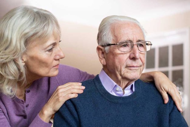 confused senior man suffering with depression and dementia being comforted by wife