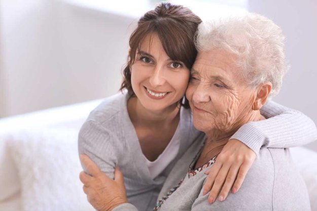 happy elderly woman with her daughter at home