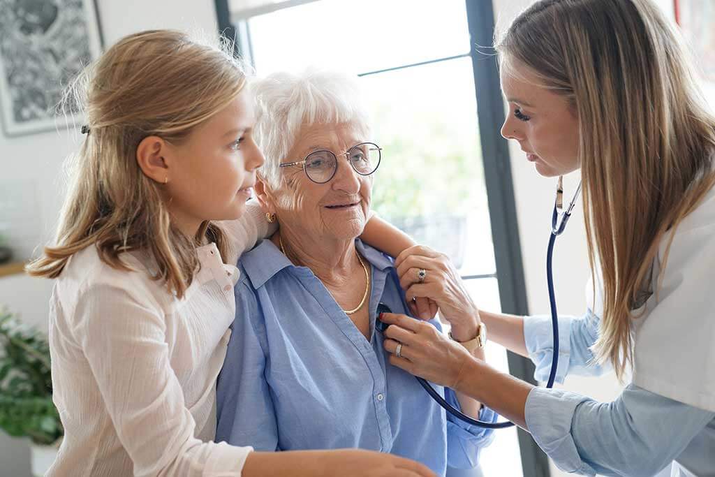 nurse checking on elderly woman heartbeat