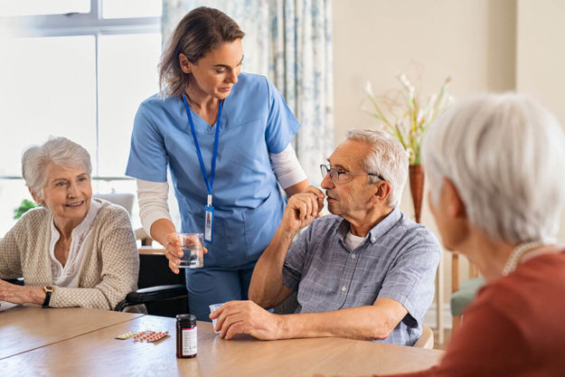 nurse helping senior man to take his daily medicine at hospice nurse helping senior man to take his daily medicine at hospice