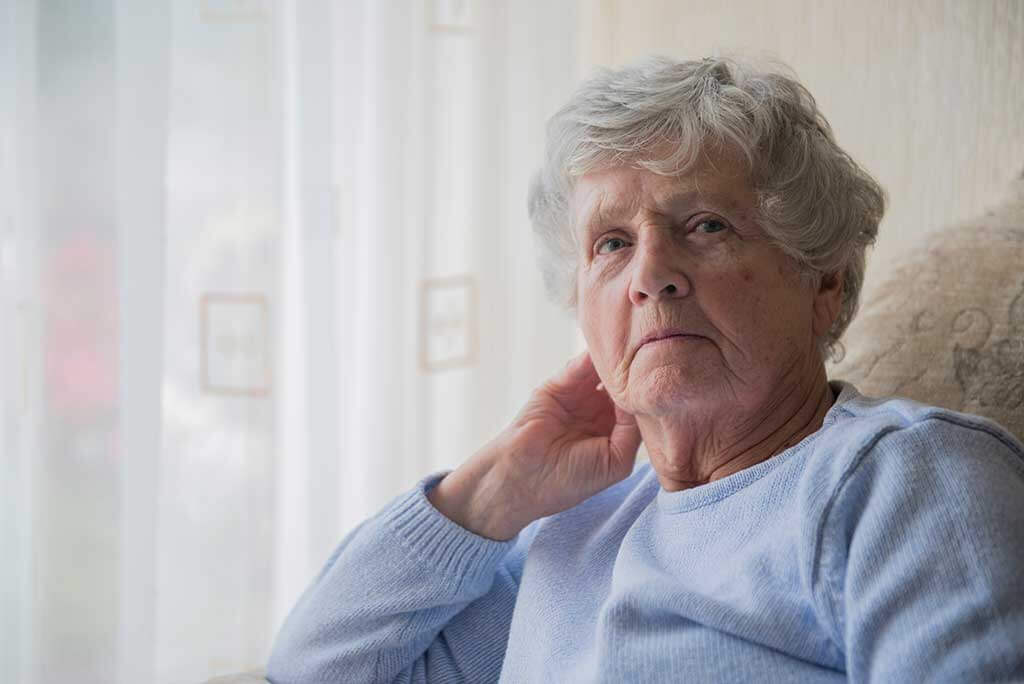 senior woman indoors looking upset and bored