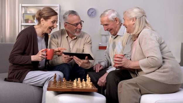smiling pensioners watching online video tablet together playing chess hobby smiling pensioners watching online video tablet together playing chess hobby
