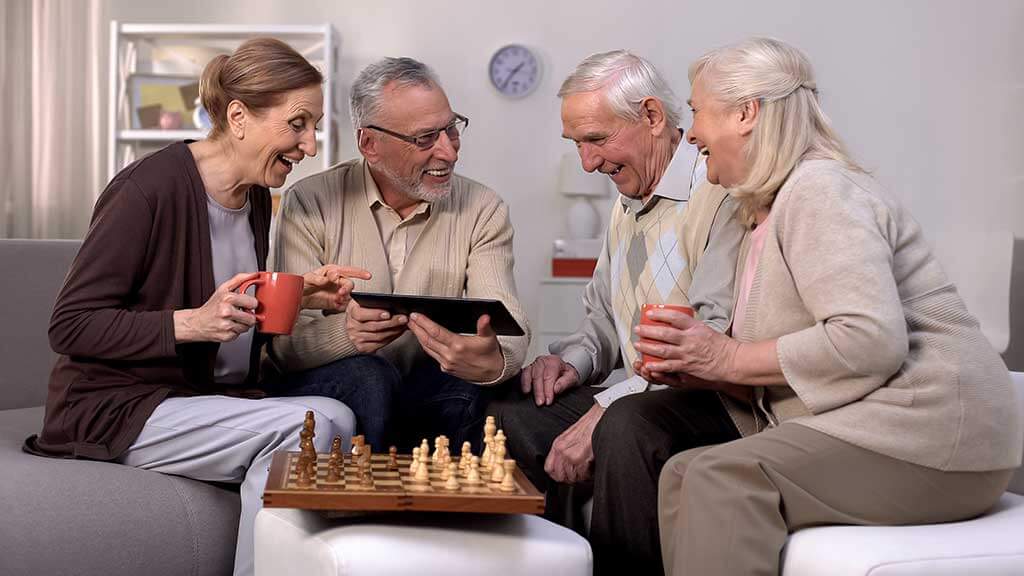 smiling pensioners watching online video tablet together playing chess hobby smiling pensioners watching online video tablet together playing chess hobby