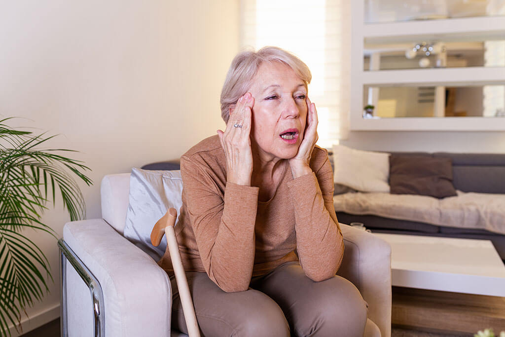 unhappy retired senior woman holding her head with pain expression face