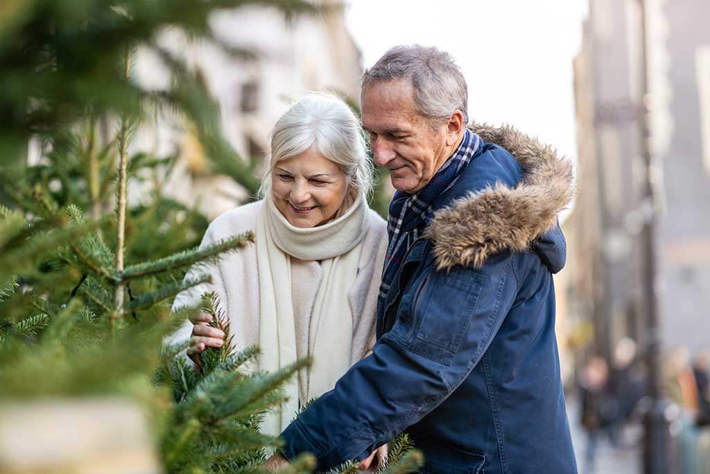 Senior couple choosing Christmas tree at Christmas market Senior couple choosing Christmas tree at Christmas market