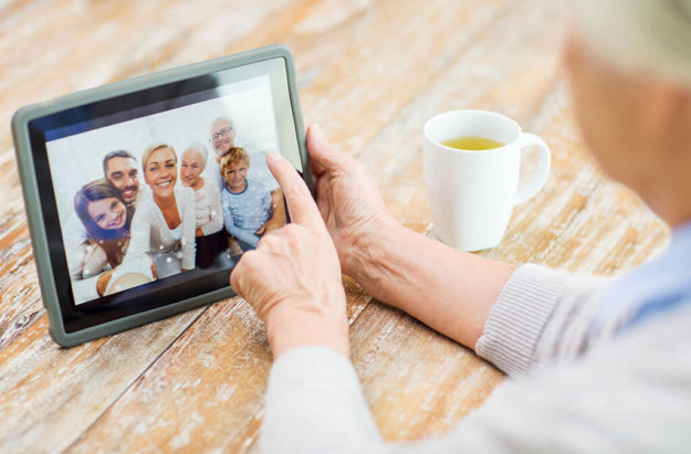senior woman with family photo on tablet pc screen senior woman with family photo on tablet pc screen