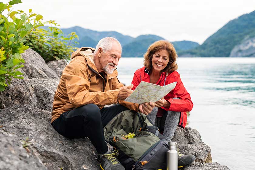a senior pensioner couple hiking by lake in nature using map a senior pensioner couple hiking by lake in nature using map
