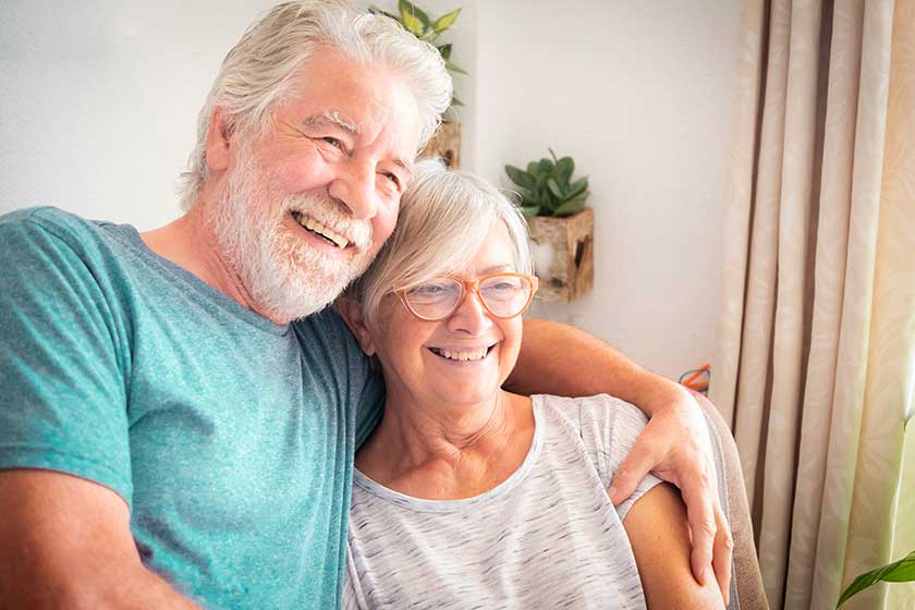 an attractive elderly couple relax on the colorful armchair by embracing each other an attractive elderly couple relax on the colorful armchair by embracing each other