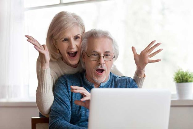 excited senior mature couple surprised by good unbelievable news unexpected win