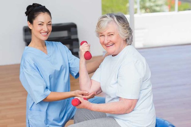 instructor assisting senior woman in lifting dumbbells instructor assisting senior woman in lifting dumbbells