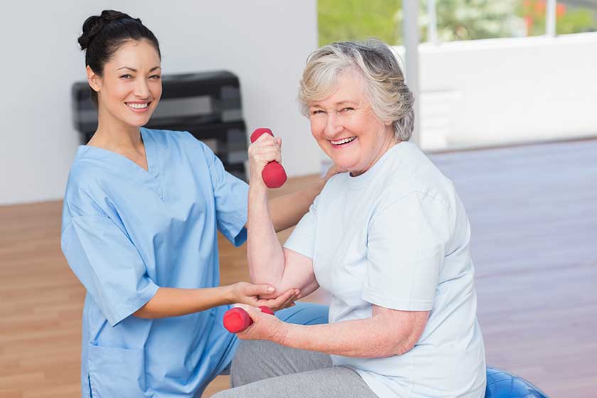 instructor assisting senior woman in lifting dumbbells instructor assisting senior woman in lifting dumbbells