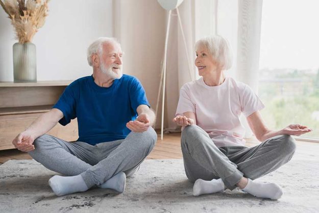 old elderly senior caucasian grandparents fit couple family spouses meditating together at home old elderly senior caucasian grandparents fit couple family spouses meditating together at home