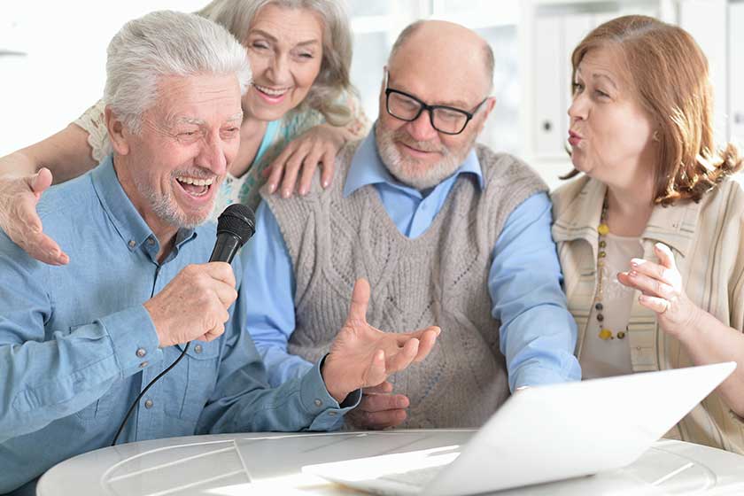 portrait of two senior couples reading newspaper
