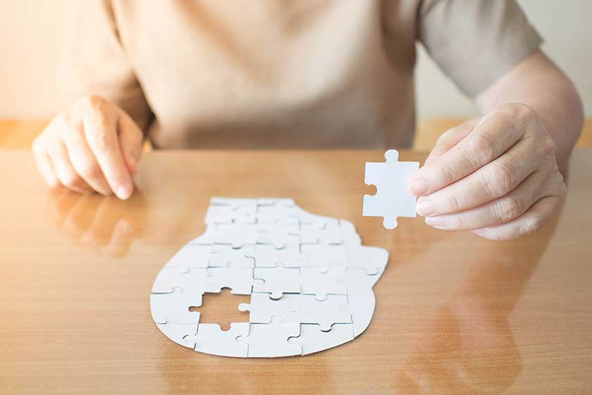 elderly woman hands holding missing white jigsaw puzzle piece
