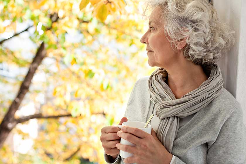 grauhaarige attraktive frau geniesst den sonnigen herbst