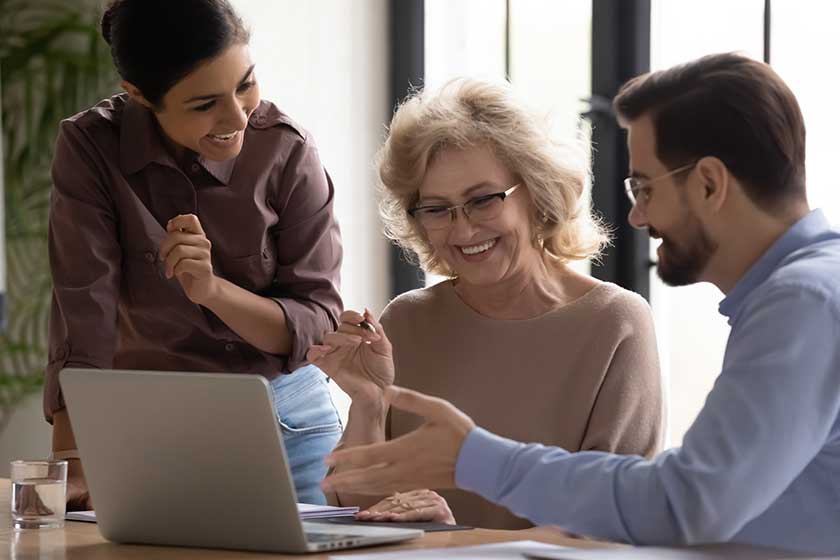 smiling mature 60 year old businesswoman using laptop smiling mature 60 year old businesswoman using laptop