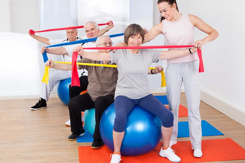 trainer assisting senior people at gym