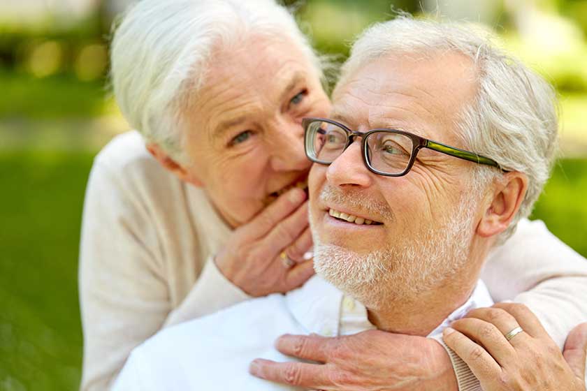 close up of senior couple whispering outdoors close up of senior couple whispering outdoors