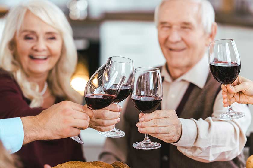 senior couple clinking glasses with family during holiday celebration