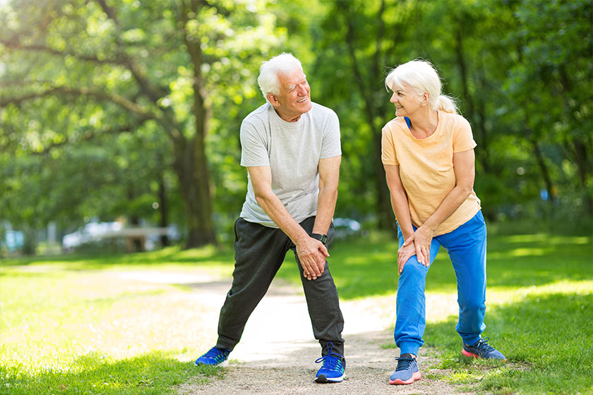 senior couple exercising in park