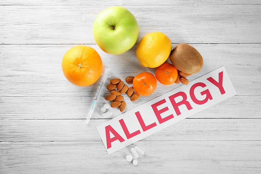 word allergy food and syringe on wooden background