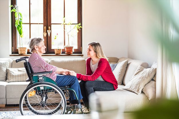 an elderly grandmother in wheelchair with an adult granddaughter