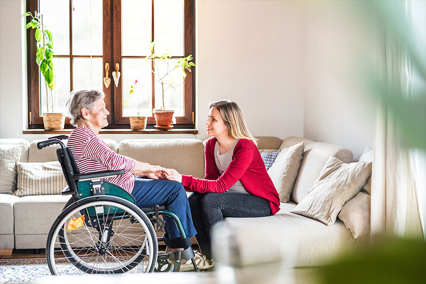 an elderly grandmother in wheelchair with an adult granddaughter