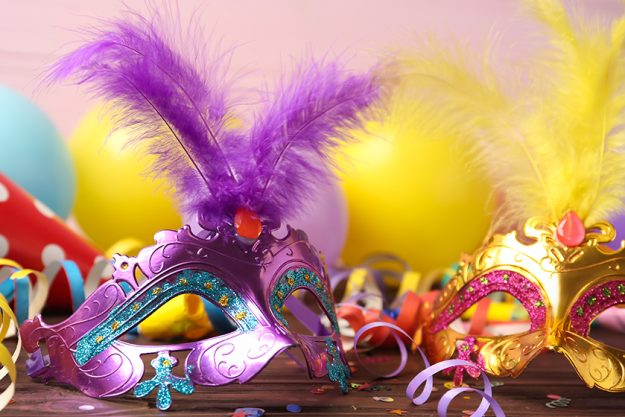 beautiful carnival masks and party decor on wooden table beautiful carnival masks and party decor on wooden table
