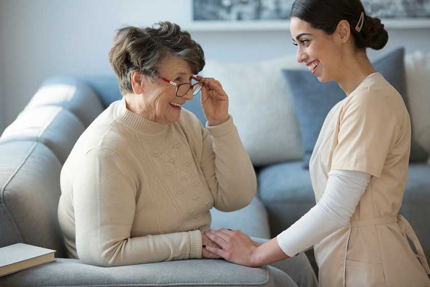 caregiver and smiling older woman