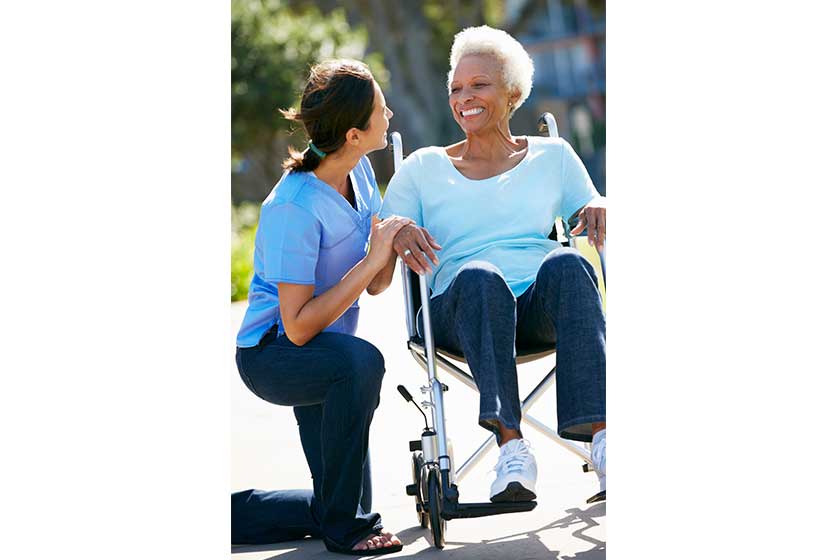 carer pushing senior woman