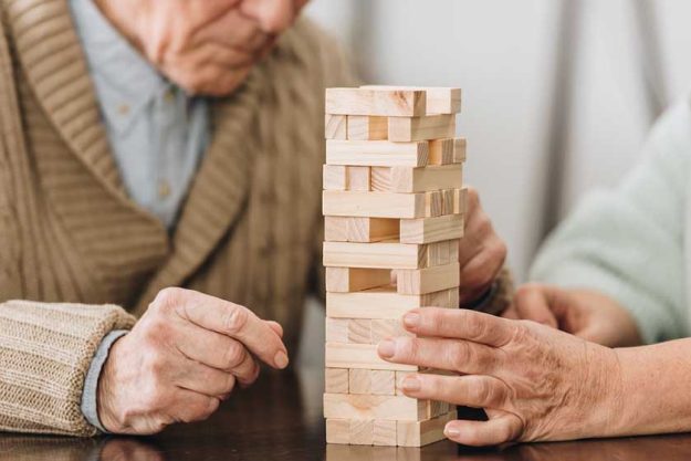 cropped view of senior couple playing jenga at home