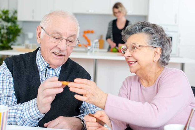 happy elderly couple eating dinner happy elderly couple eating dinner