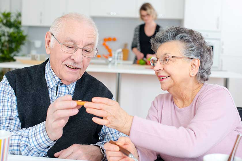happy elderly couple eating dinner