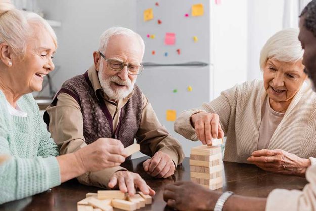happy interracial pensioners smiling while playing happy interracial pensioners smiling while playing