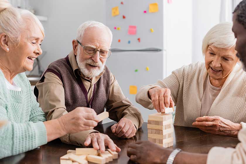 happy interracial pensioners smiling while playing happy interracial pensioners smiling while playing