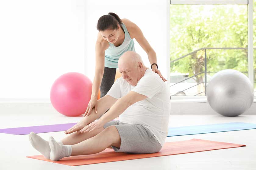 instructor helping senior man to practice yoga instructor helping senior man to practice yoga