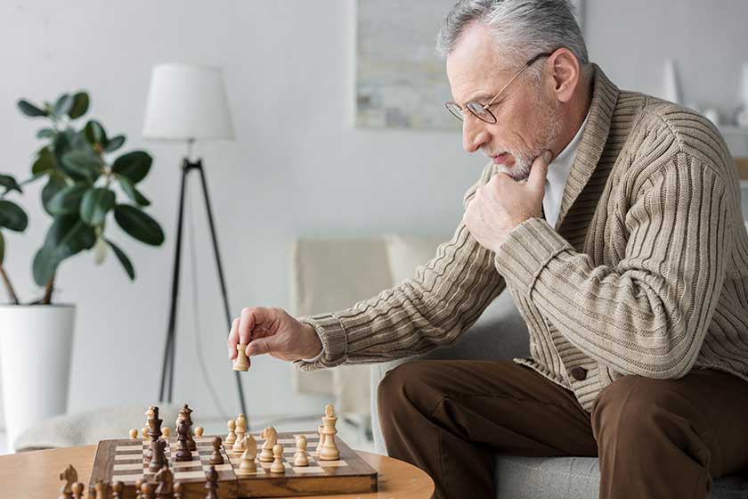 retired man glasses thinking while playing chess