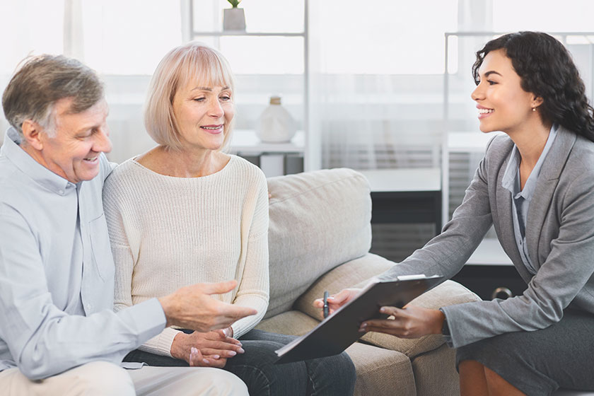 senior couple consulting with adviser at office