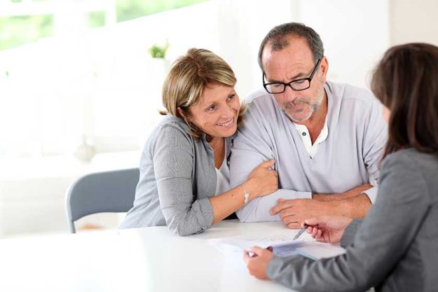 senior couple signing financial contract