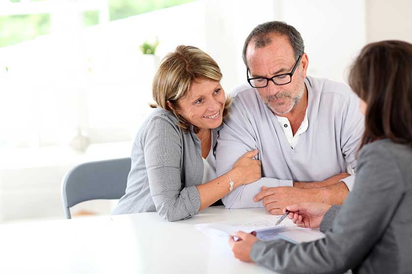 senior couple signing financial contract