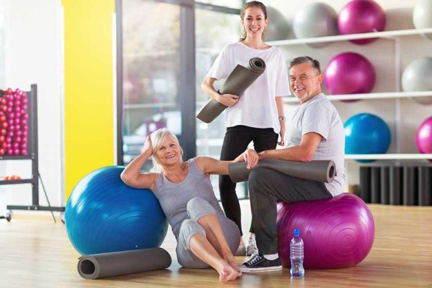 senior couple training in the gym with a personal trainer