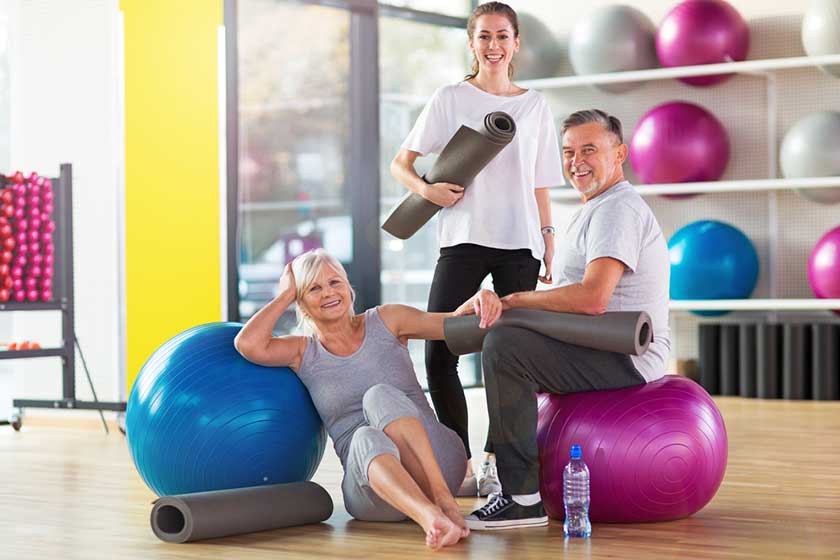 senior couple training in the gym with a personal trainer